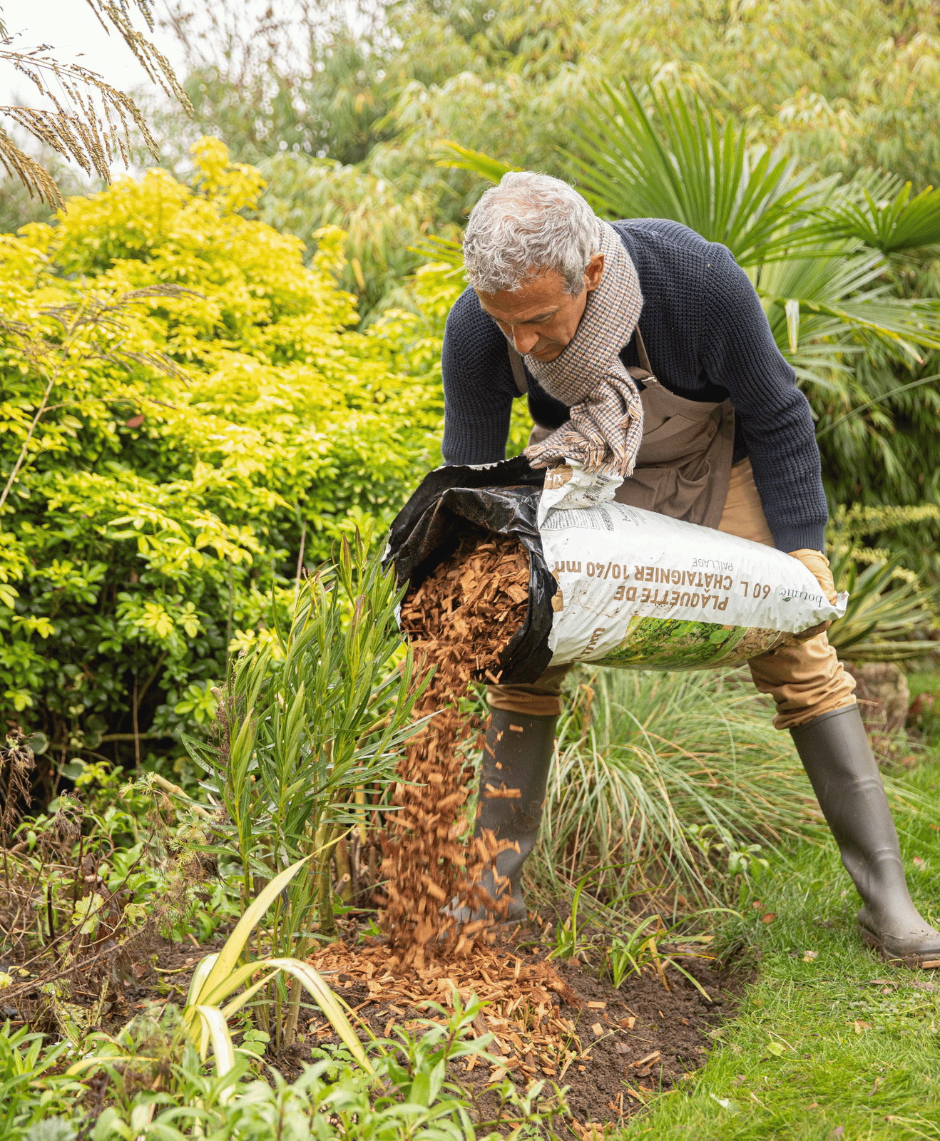 homme qui recouvre sa terre battue avant l'hiver