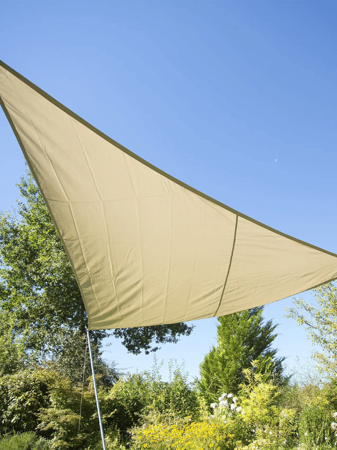 Un voile d'ombrage étend un dans un jardin