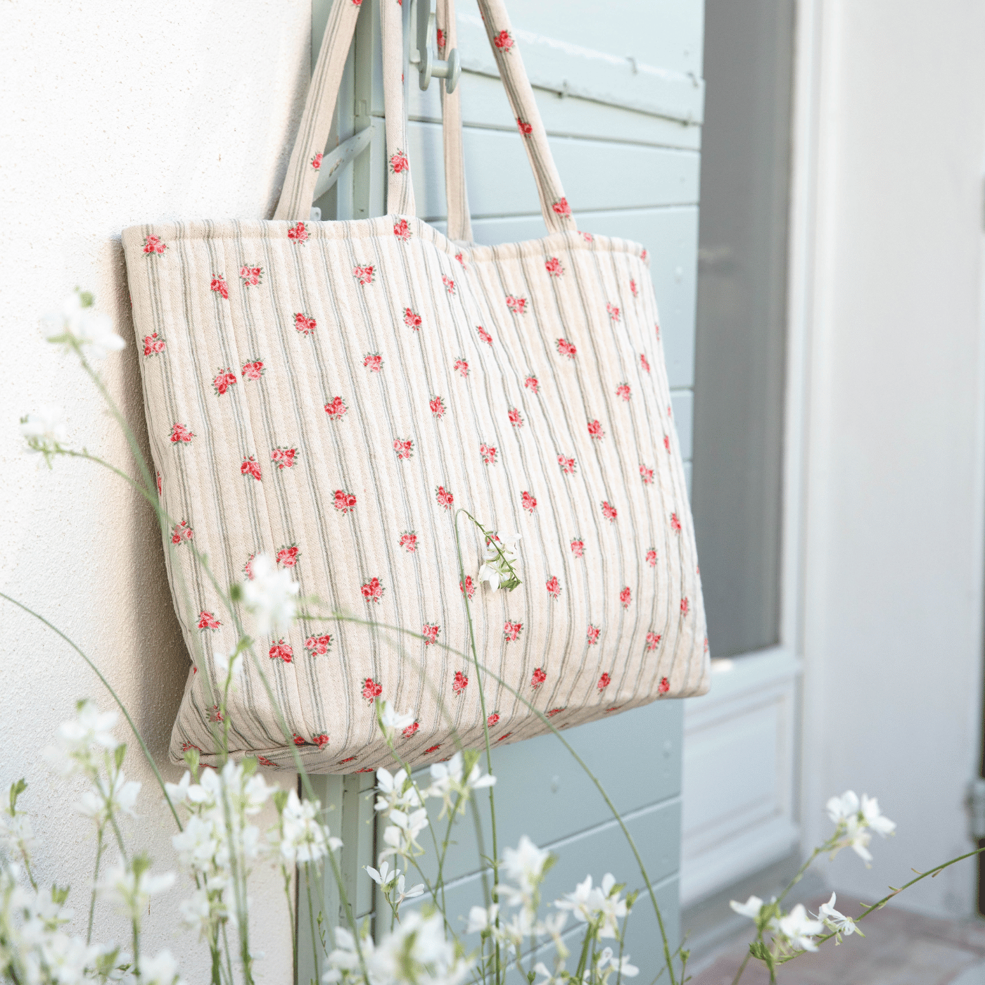 Un sac cabas matelassé accrocher sur un volet