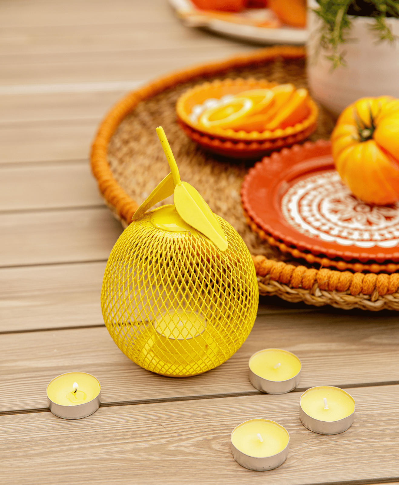Des bougies à la citronnelle avec un porte bougies posé sur une table en bois