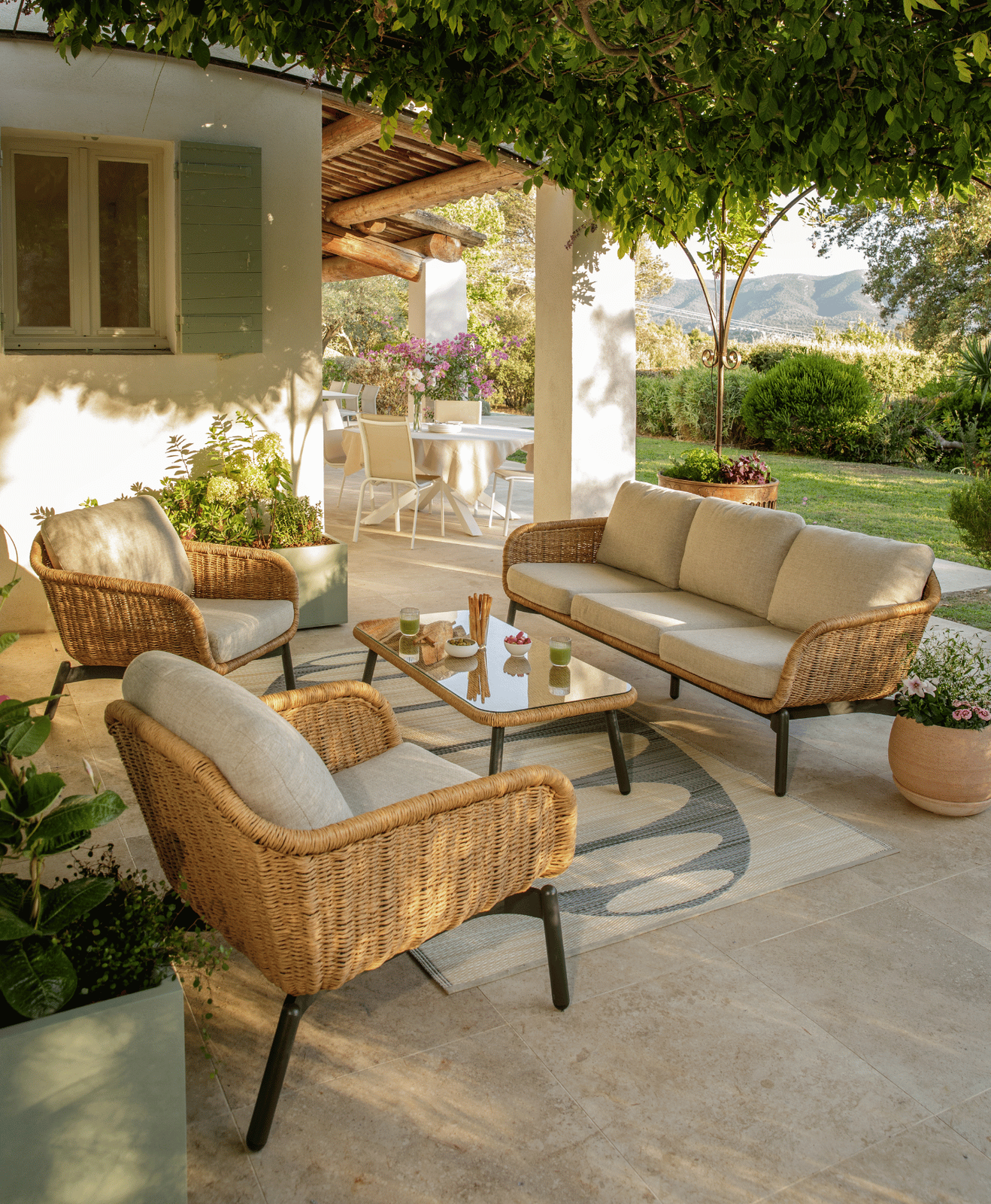 Présentation du salon bas Aralia sur une terrasse sous une pergola végétalisée
