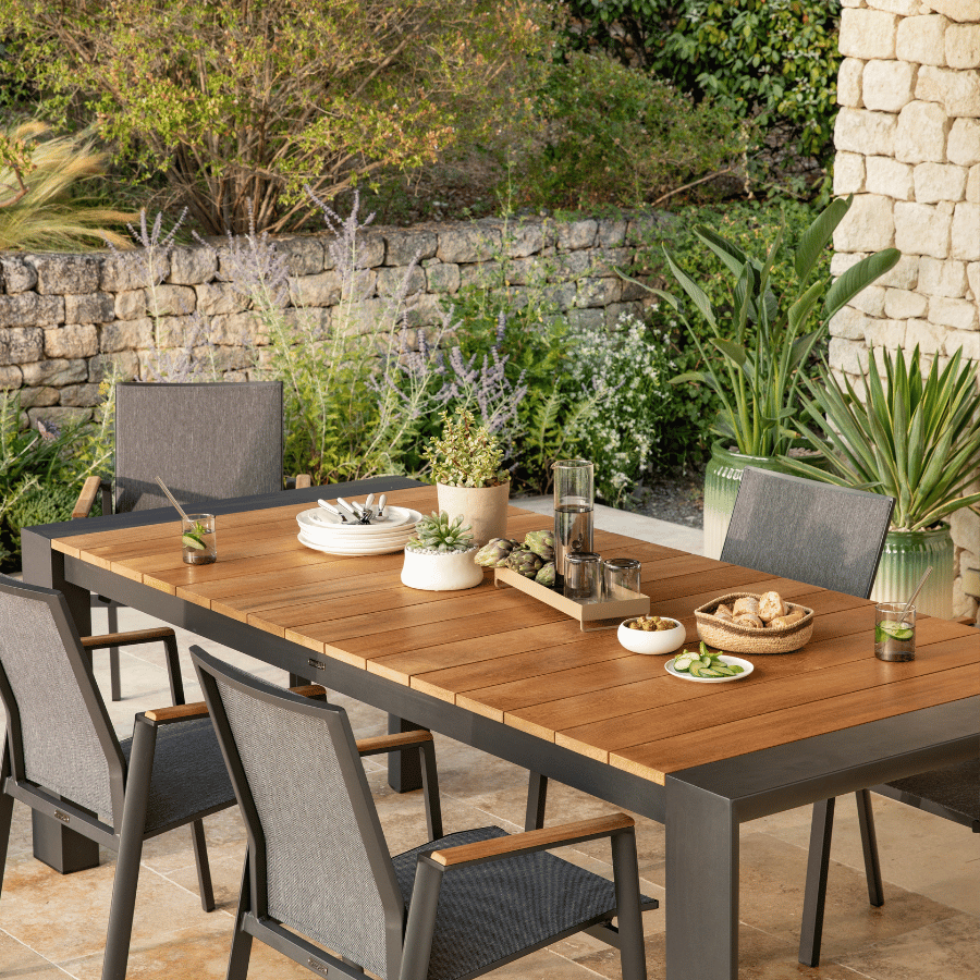 Une table à manger en bois noir, sublimée par des végétaux pour une ambiance naturelle et élégante