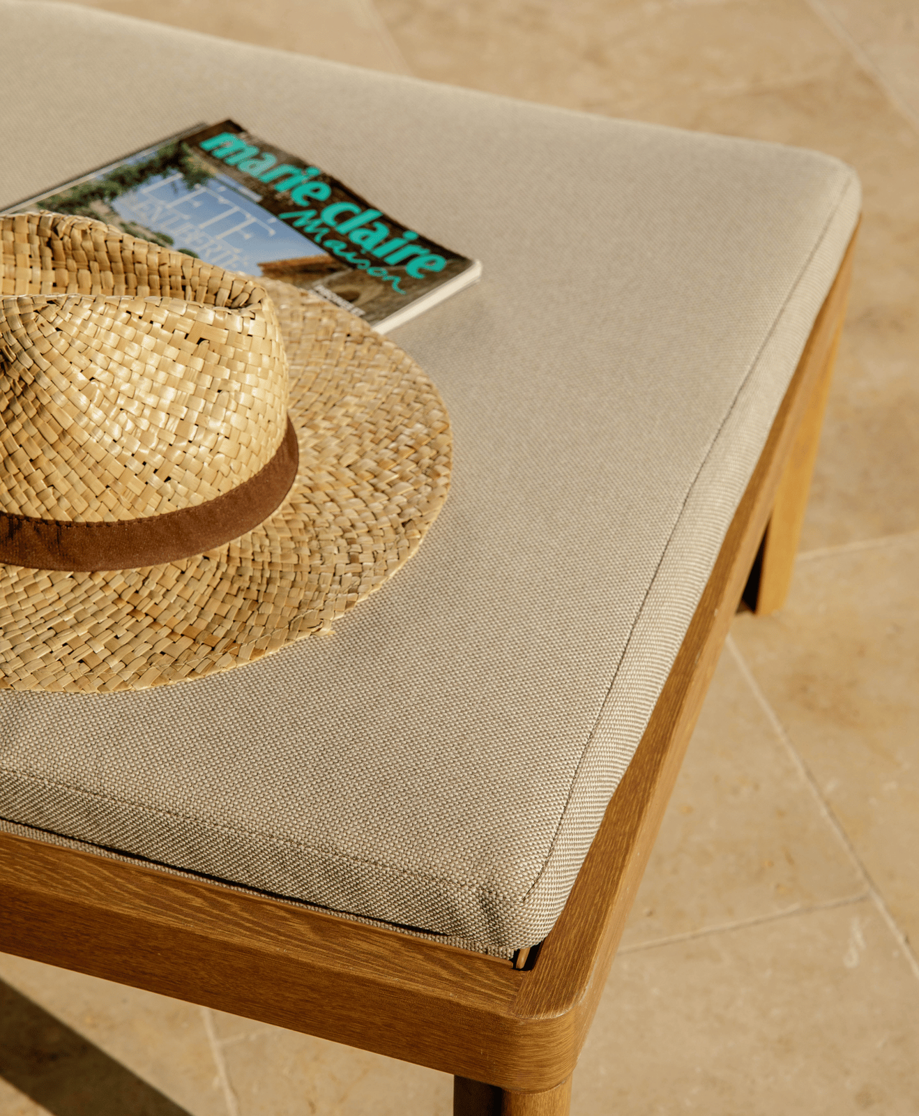 Zoom sur le matelas d'un bain de soleil avec un chapeau et un magazine