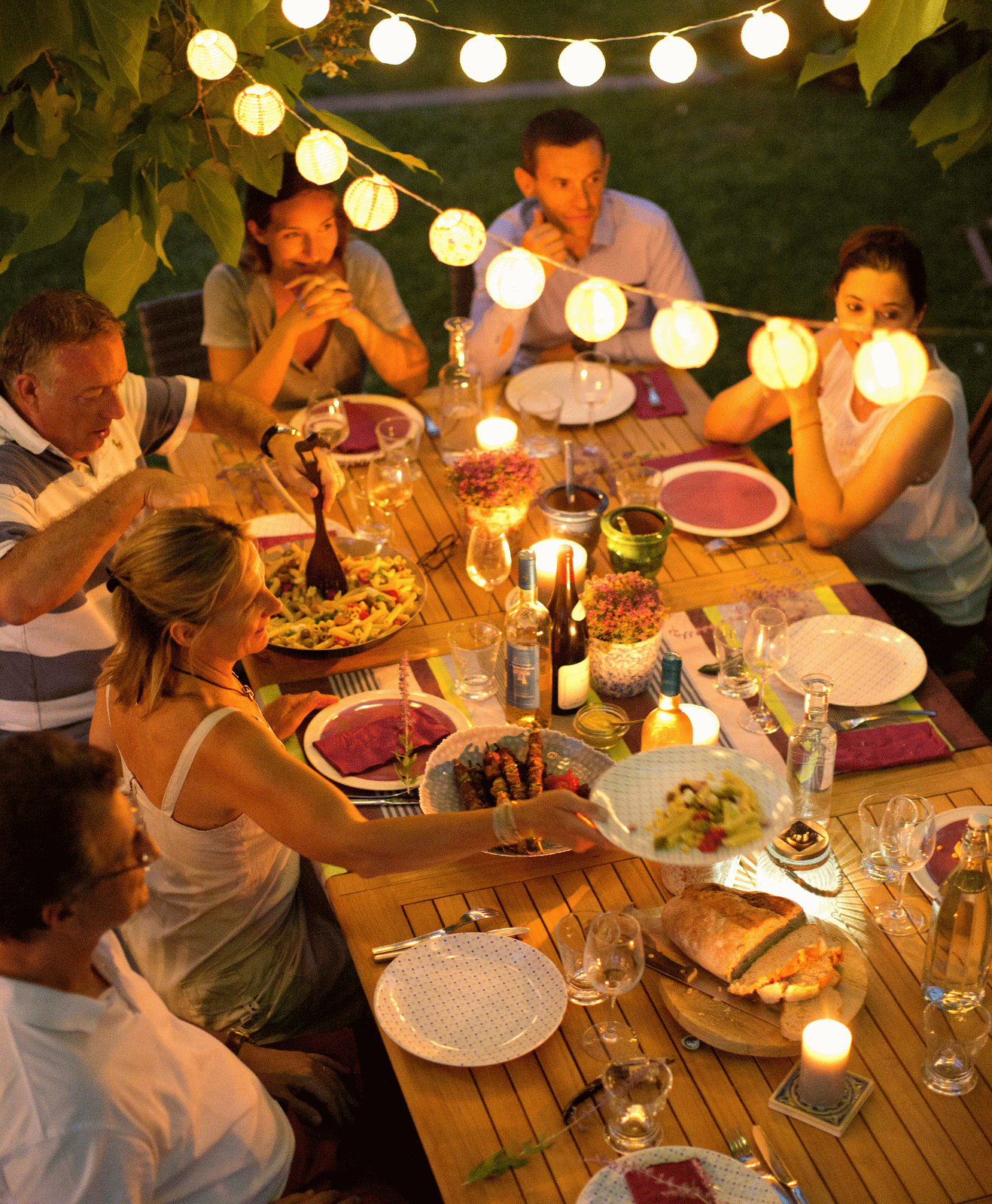 Des amis rassemblés autours d'une table pour un repas d'été