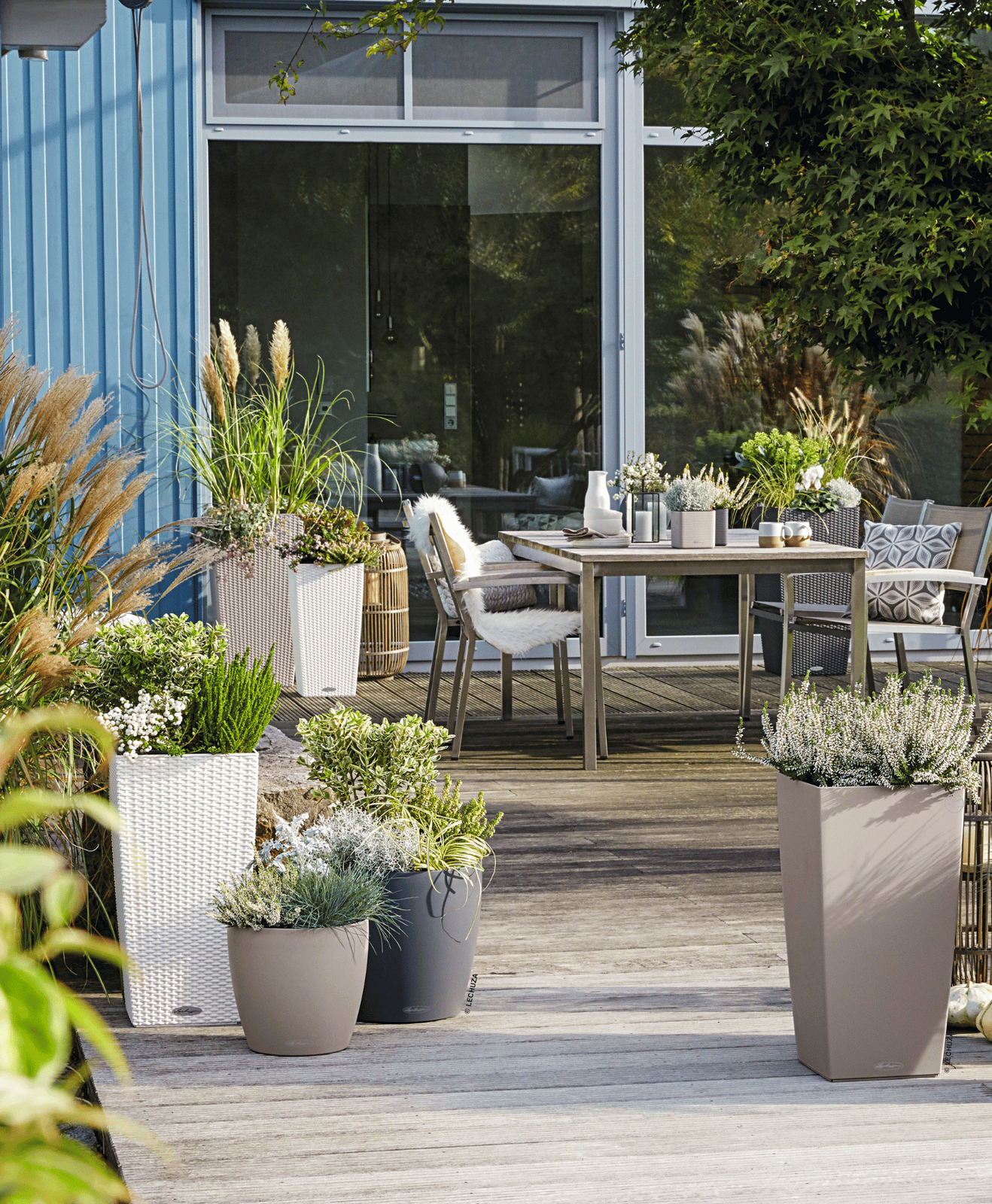 Une terrasse aménagée avec une table, des chaises, des pots et des décorations