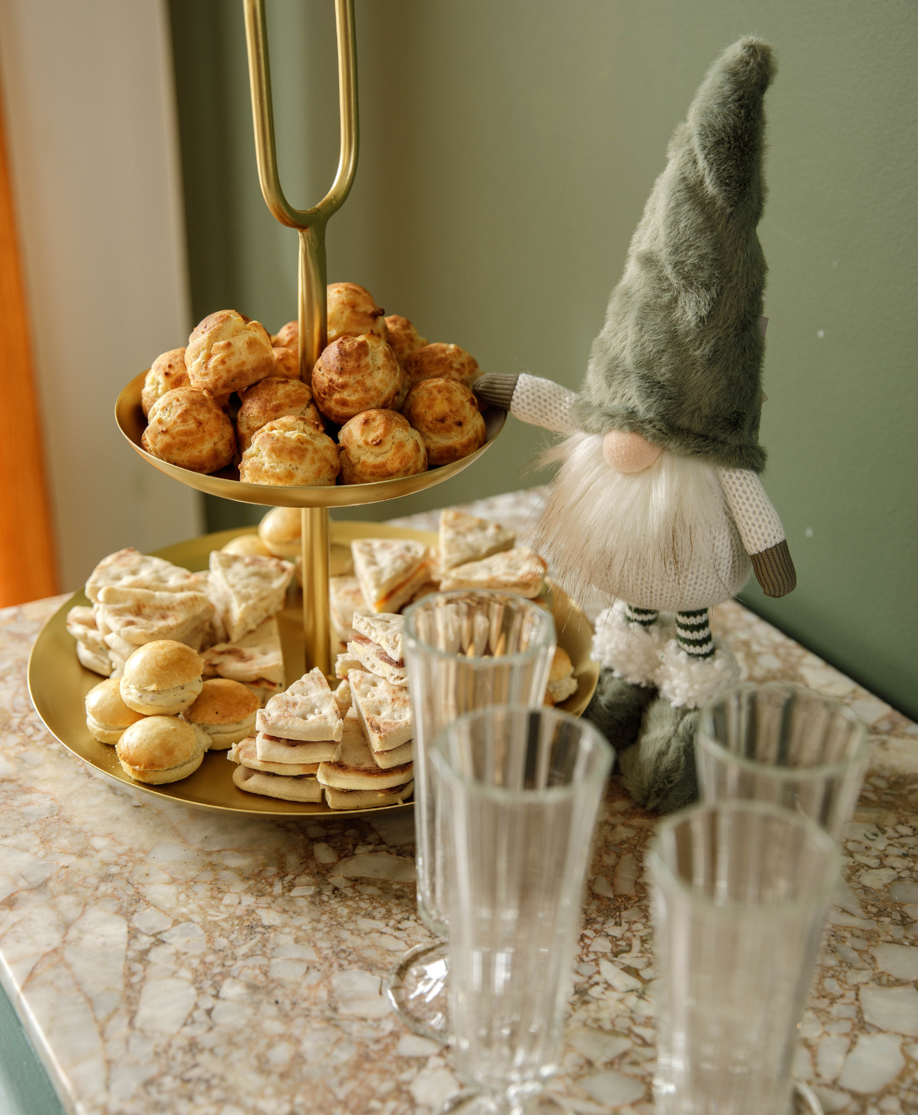Un plateau de petits four avec des verres posés sur une étagères