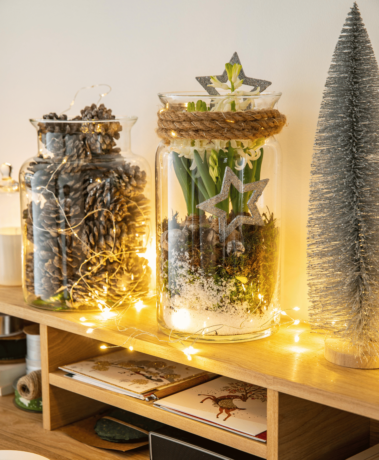 Une décoration de noël sur une étagère avec une guirlande lumineuse