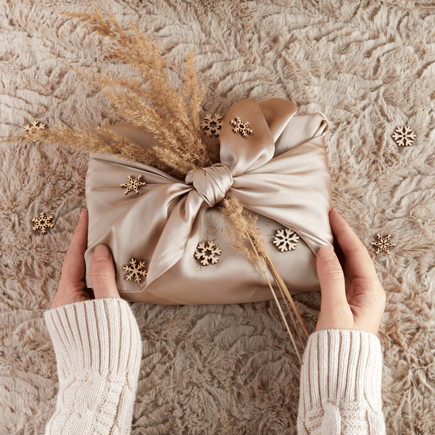 Une femme qui tient un cadeau emballé avec la méthode furoshiki