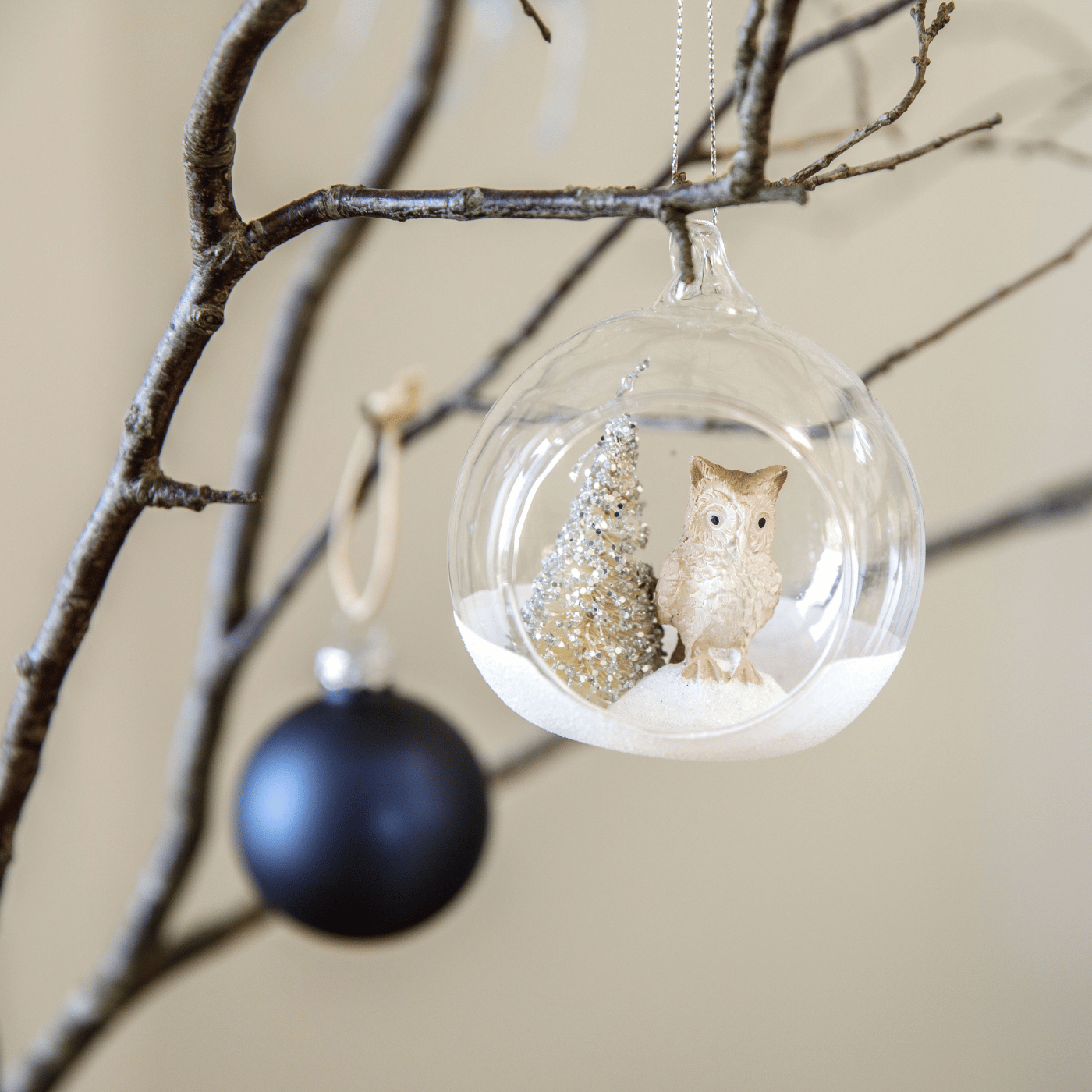 Des décorations de Noël bleue et blanches accroché à une branche