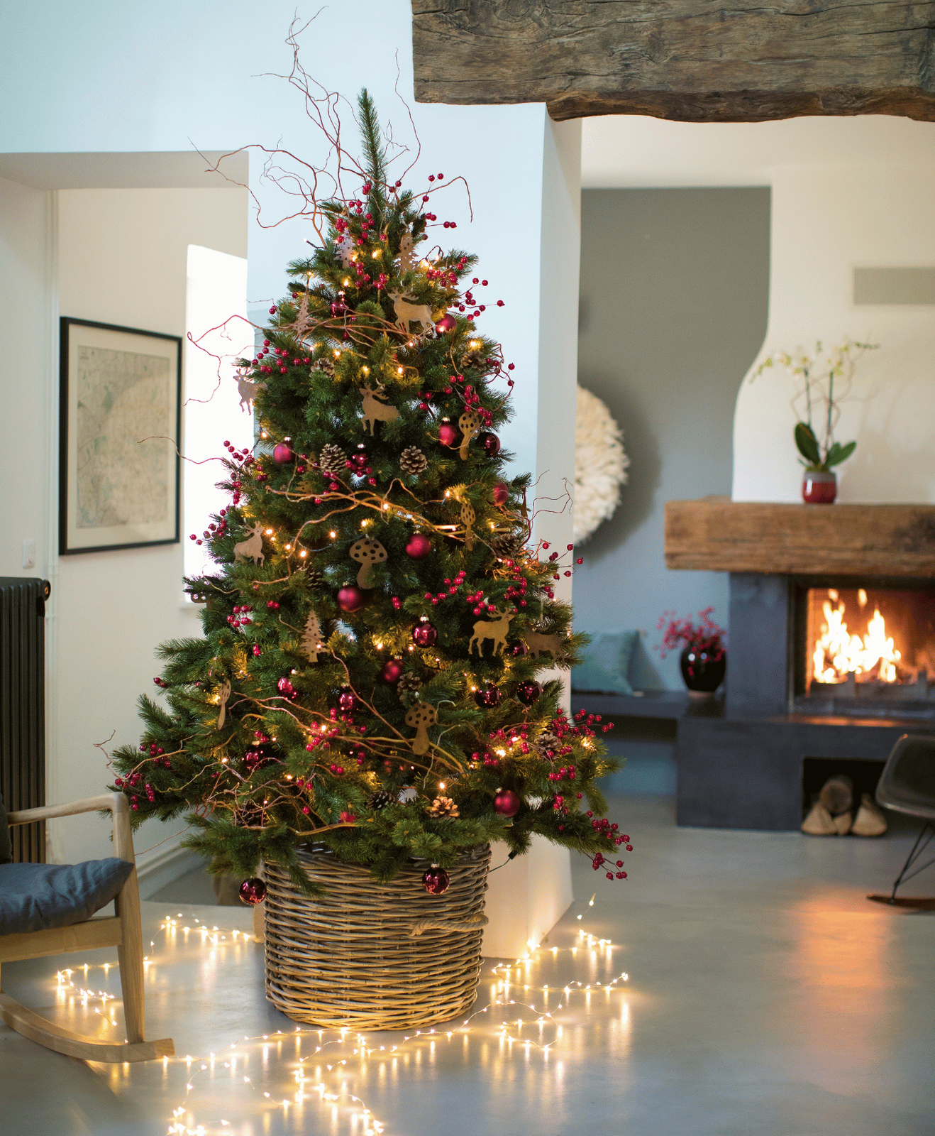 Un sapin de Noël artificiel décoré avec une guirlande lumineuse au sol
