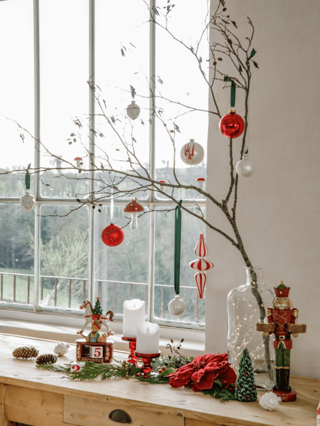 Des boules de Noël de couleur blanches et rouges accrochées à des branches d'arbre
