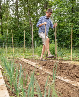 Un homme en train de préparer son sol pour planter