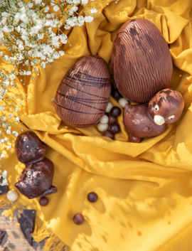 Des œufs de Pâques en chocolat sur une nappe jaune
