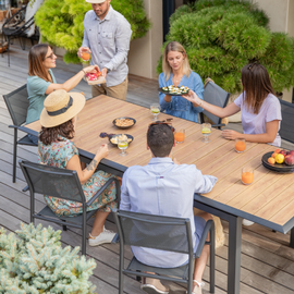 6 personnes autour d'une table de jardin qui prennent l'apéritif