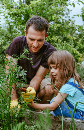 Un père et sa fille en train de jardinier