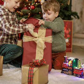 Deux enfants déballent leurs cadeaux de Noël
