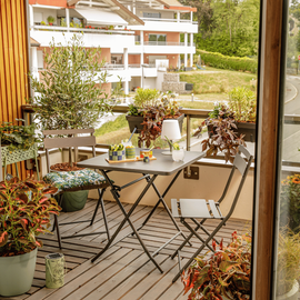 Table marron sur un balcon avec des plantes