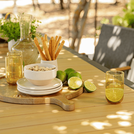 Planche apéro avec pistaches, citrons verts, verres à eau ...