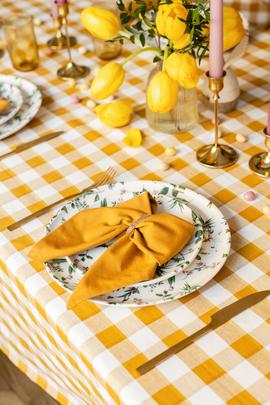Une table de Pâque dressé avec des nœuds jaune dans les assiettes