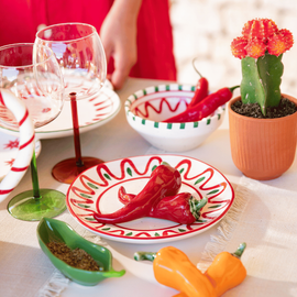 Une table d'été avec des poivrons décoratifs, des assiettes à tapas et verres de vin
