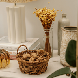 Une décoration d'automne avec un panier de noix et un bouquet de fleurs séchées
