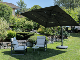 Parasol quoi fait des l'ombre sur deux chaises de jardin.