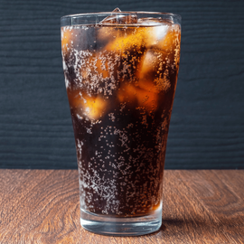 Sodas dans un grand verre transparent avec des glaçons.