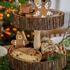 Un plateau en bois avec des biscuits de Noël et du pain aux raisins