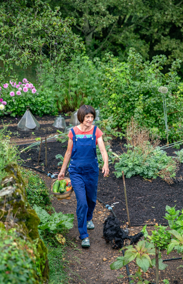 Une femme qui récolte ses fruits et légumes