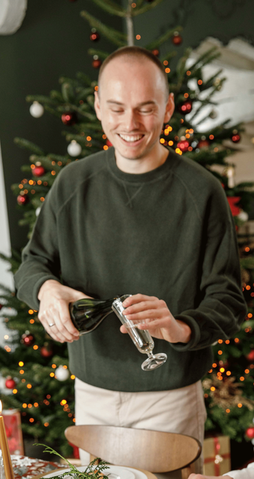 Un homme sert du champagne au repas de Noël