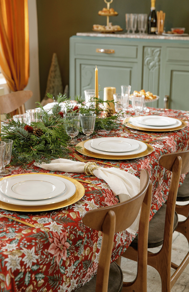 décoration de table de noël avec assiettes, nappe, bougies et centre de table