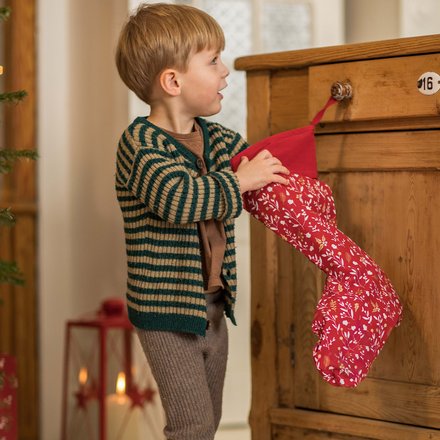 Un enfant qui cherche un cadeau dans une chaussette de Noël