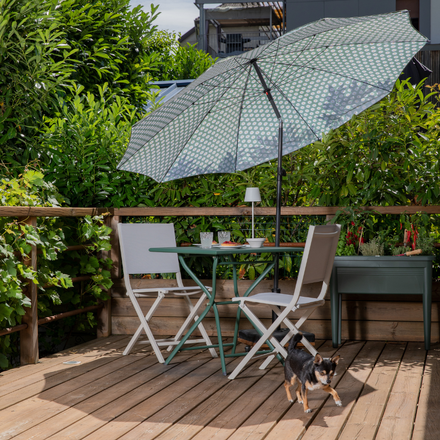 Une petite table de jardin sous un parasol sur une terrasse
