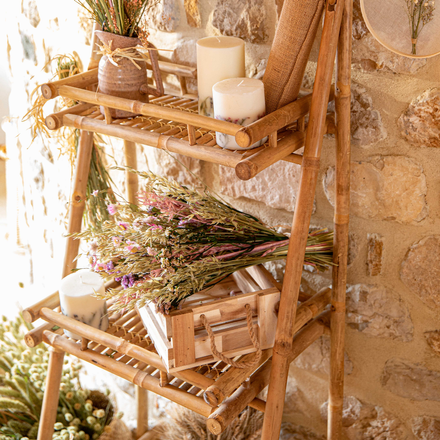 Une étagère en bois avec des fleurs séchées