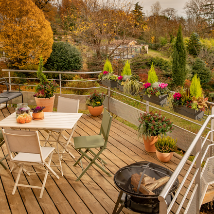 Un balcon rempli de jardinières et de pots pour l'automne