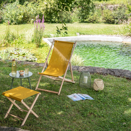 Un coin détente au jardin : une chilienne proche d'une piscine naturelle