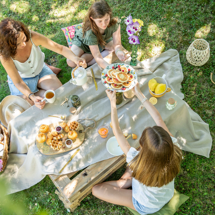 Une mère et ses filles autour d'un brunch en extérieur pour la fête des mères