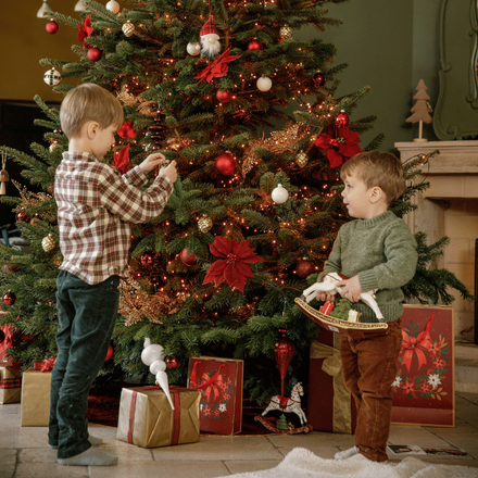 Des enfants en train de jouer près du sapin de Noël