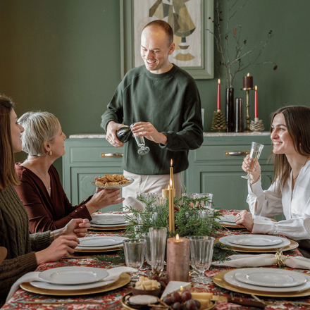 Un repas de Noël en famille avec un homme en train de servir l'apéritif