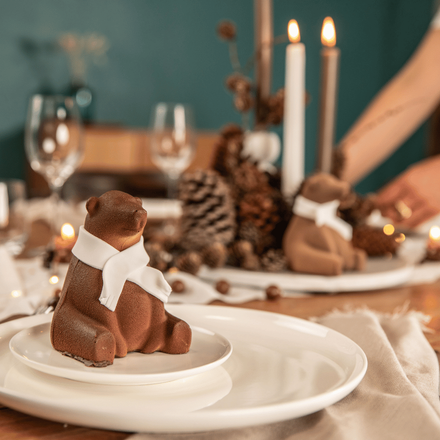 Une table de Noël dressée avec un petit ours en chocolat
