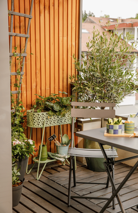 Le coin d'un balcon urbain aménager avec table, chaise et verdure