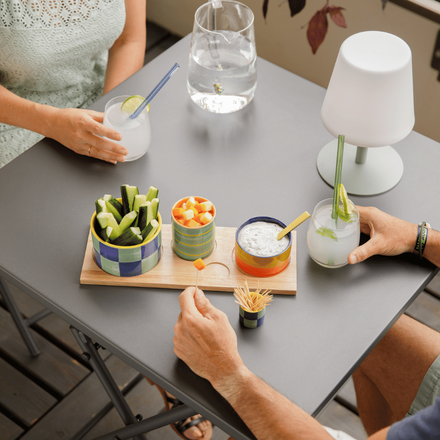 deux personnes qui boivent un verre autour d'une table ave un plateau de crudité