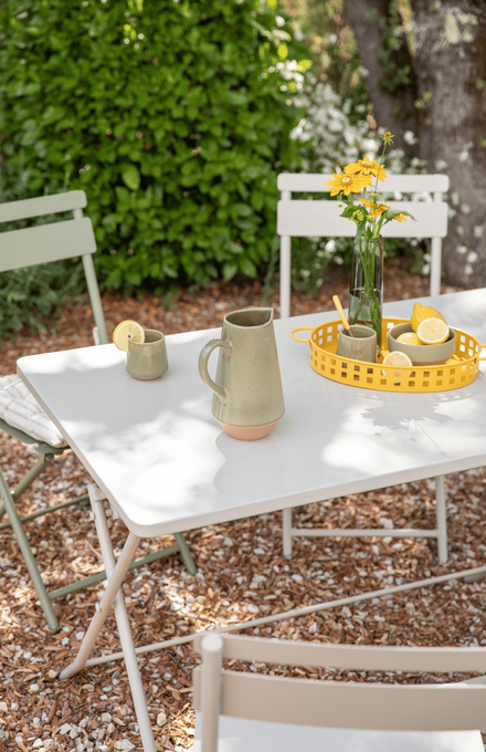 table clivia beige dans un jardin avec de la petite déco