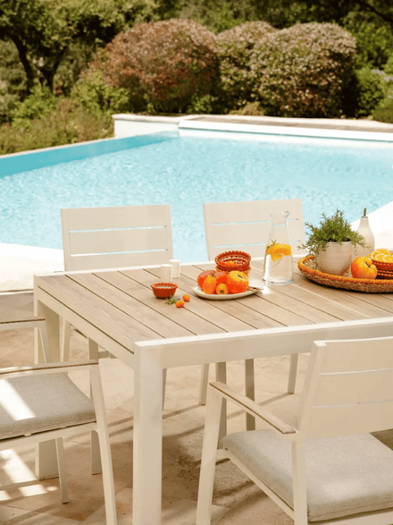 Une table Calla blanche devant la piscine