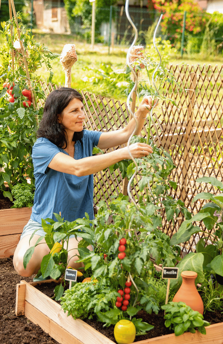 Une femme accroupie qui s'occupe de son petit potager