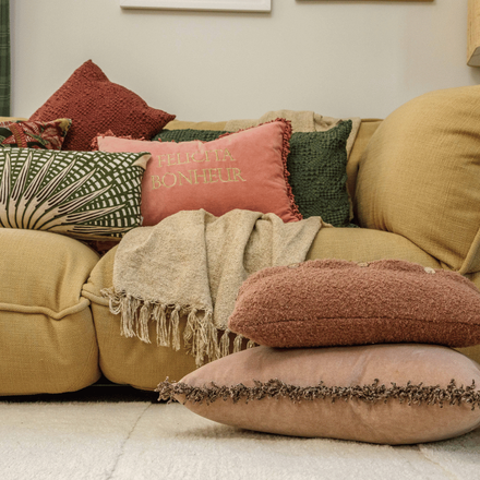 Un canapé avec plein de coussins colorés dans un salon