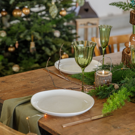 Une assiette posée sur une table en bois avec un verre et une serviette