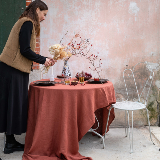 Une table drapée, et une femme qui la décore