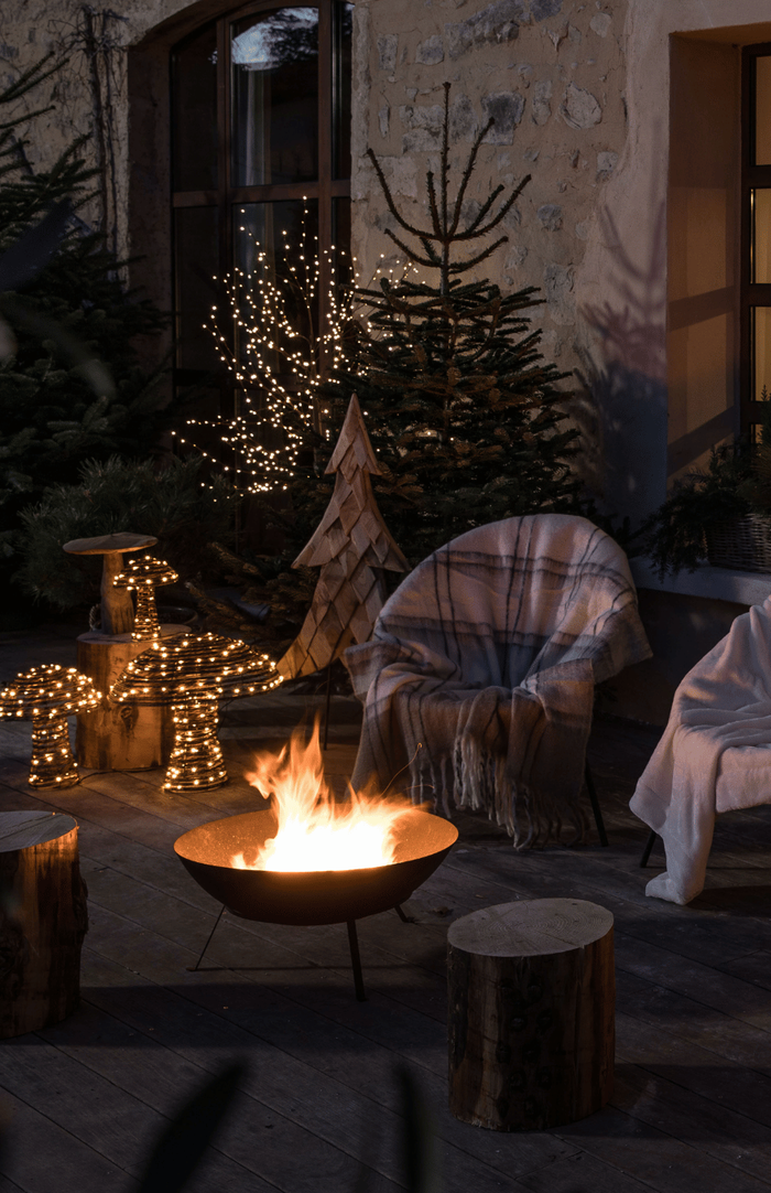 extérieur illuminé avec un feu et des décorations lumineuses