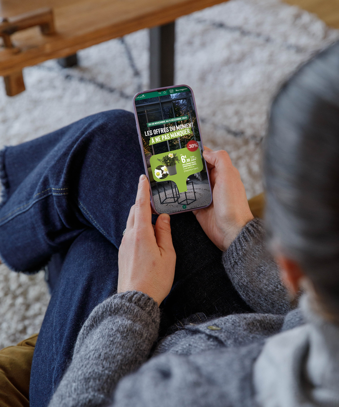 Une femme en train de consulter une brochure sur son smartphone